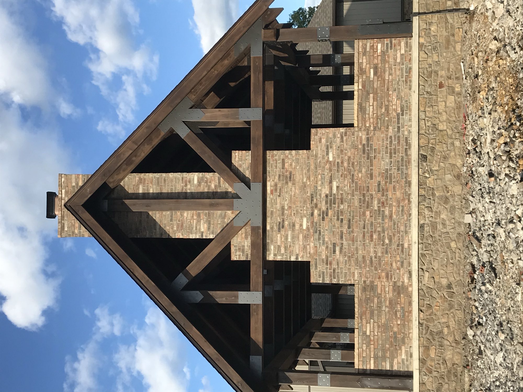 Brick and stone gable with timber trusses by Primestone Heritage